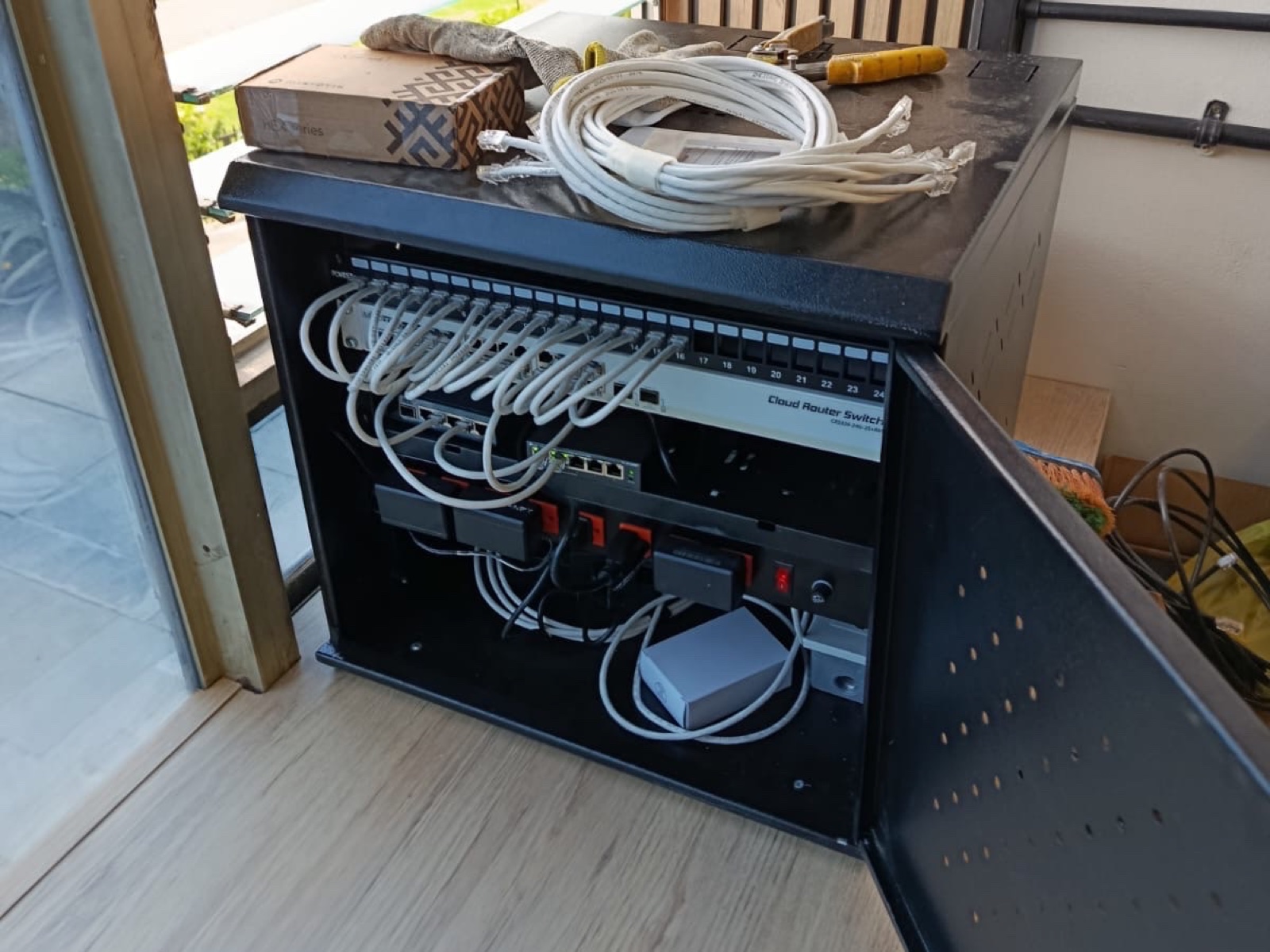 Rack de red con patch panel, switch y cableado