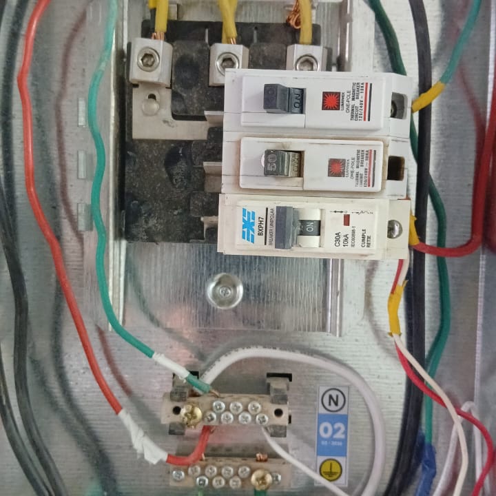 Tablero eléctrico abierto con barras de neutro y tierra