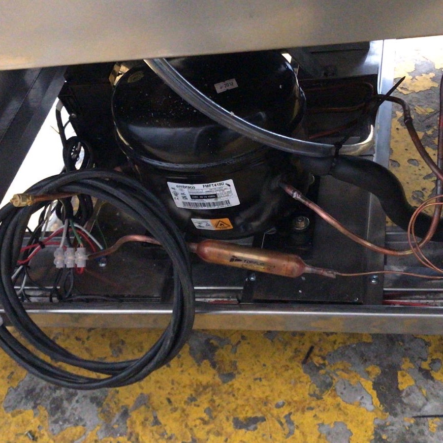 Unidad condensadora instalada bajo una mesa refrigerada