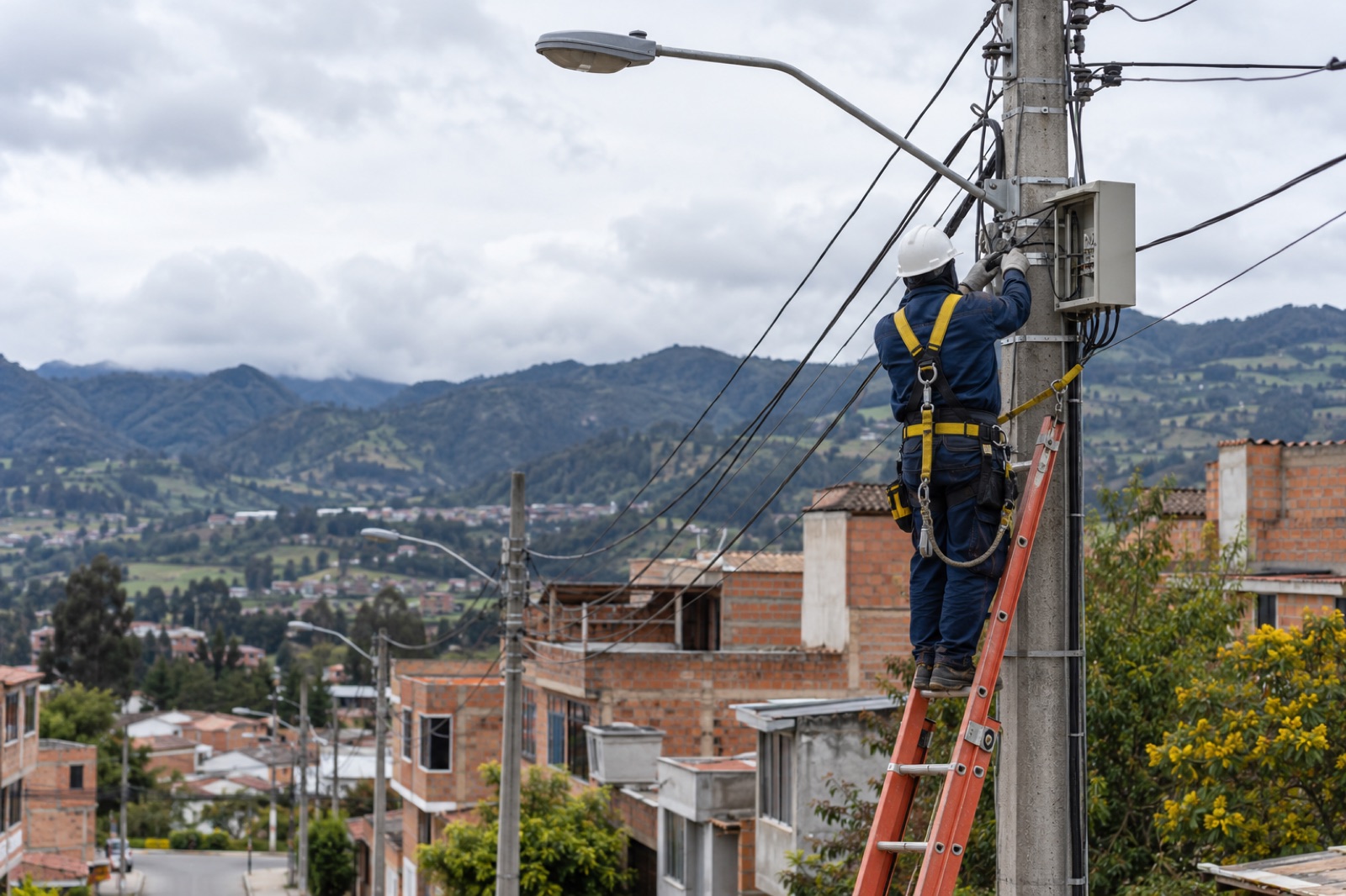 Técnico trabajando en un poste de red eléctrica en la sabana de Bogotá